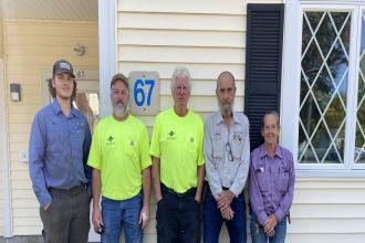 Staff Standing Next to House