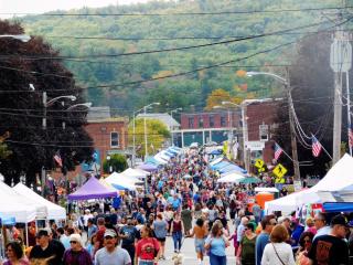 A street lined with vendors' booths and festival attendees.