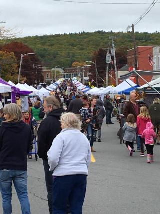 An image of 2019 FallFest, showing the upward slope of Central Street, crowded with visitors and vendor tents 